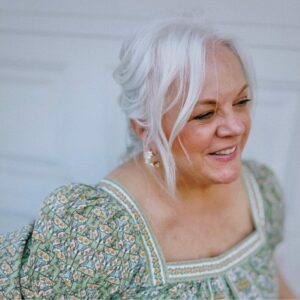 Kim Zimmerman, smiling, in a green floral dress