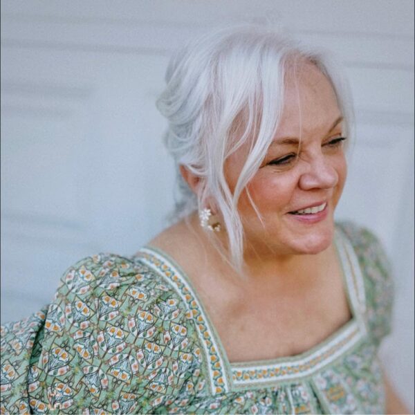 Kim Zimmerman, smiling, in a green floral dress