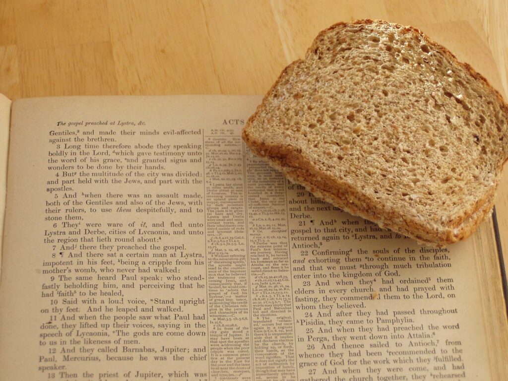 A slice of bread on an open Bible